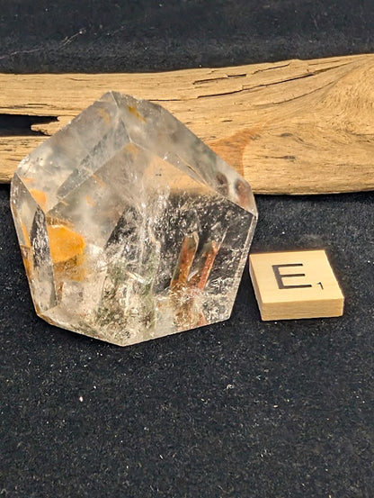 Exact piece Garden Quartz faceted freeform, Variant E1, featuring striking reddish-brown tubular iron oxide inclusions within clear quartz.