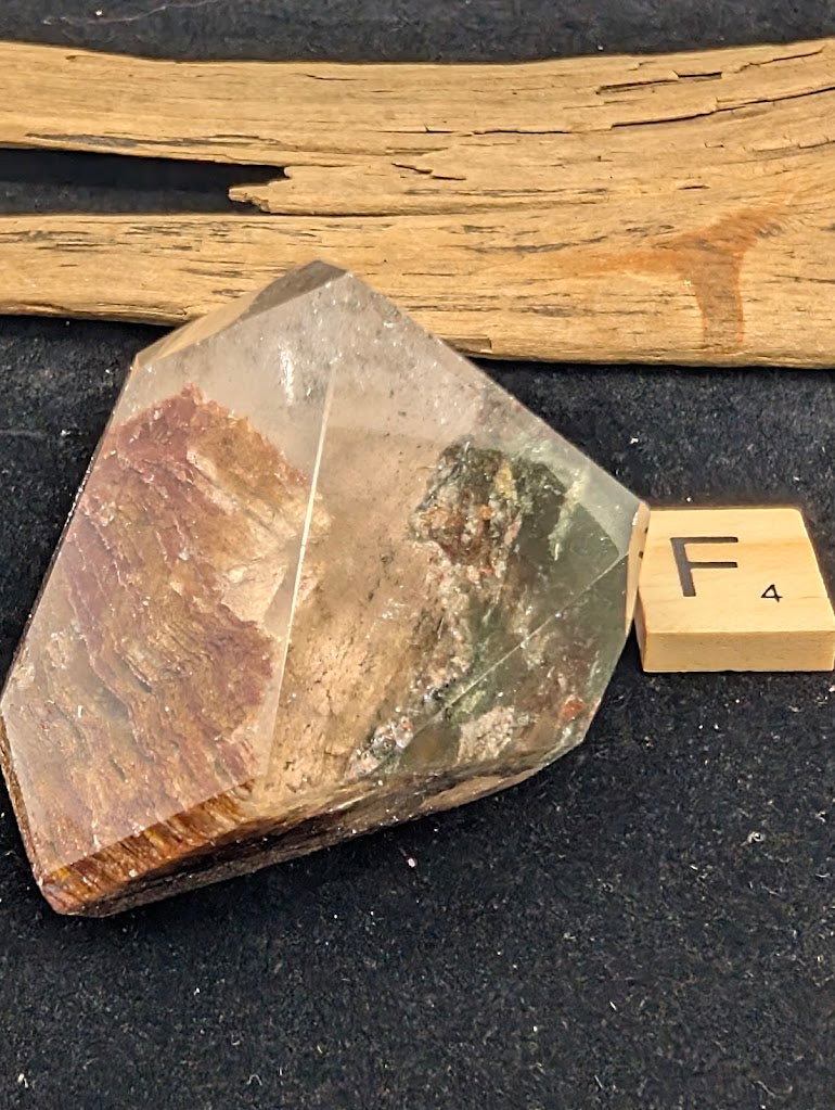 Angled view of exact piece Garden Quartz faceted freeform, Variant F4, highlighting the internal ridgeline and minor green chlorite.