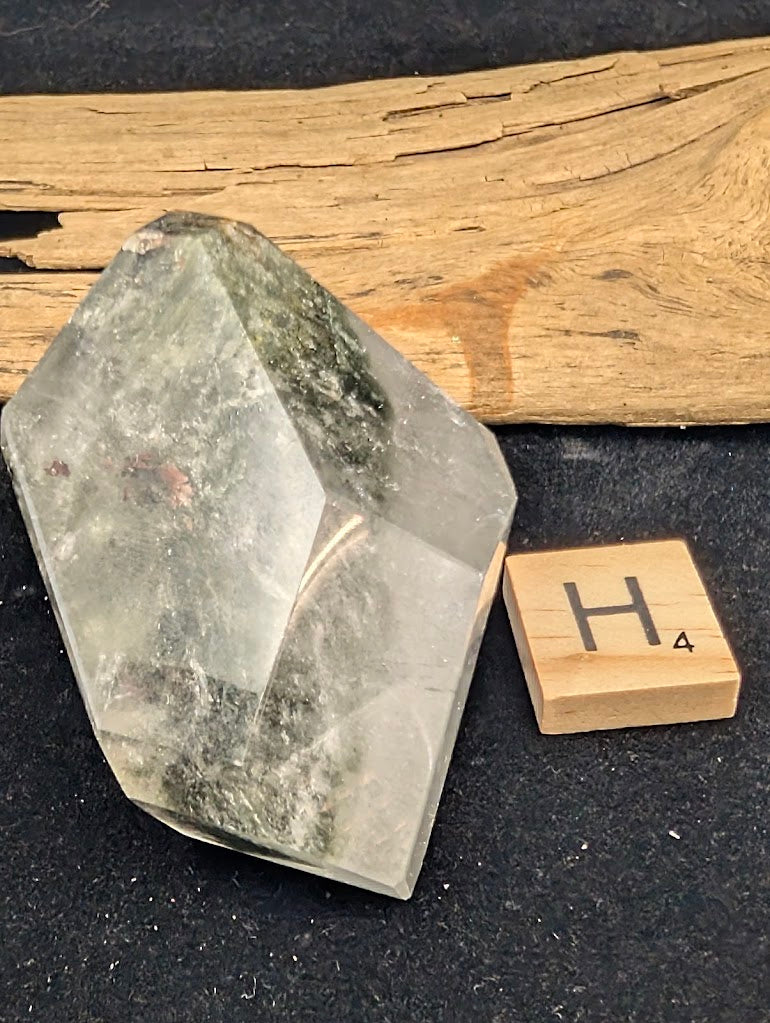 Exact piece Garden Quartz faceted freeform, Variant H4, featuring a prominent, dense vein of deep green chlorite running diagonally.