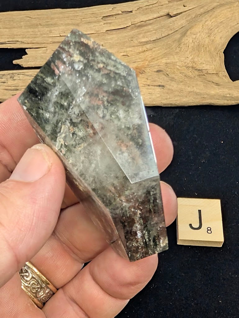 Angled view of exact piece Garden Quartz faceted freeform, Variant J8, showing the depth of the base inclusions.