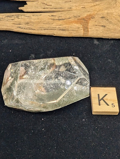 Angled view of exact piece Garden Quartz faceted freeform, Variant K5, highlighting the suspended inclusions.