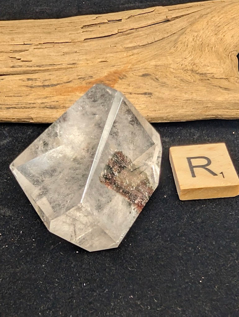 Exact piece Garden Quartz broad freeform, displaying high clarity above a striking, dense cluster of green and red minerals at the base.