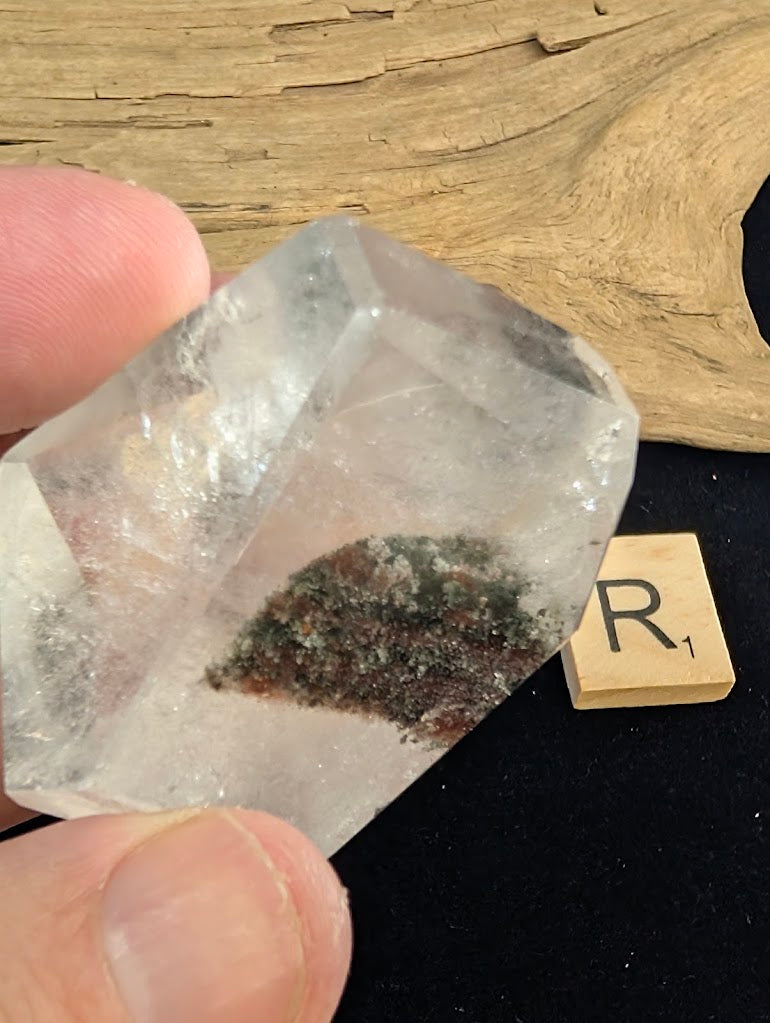 Exact piece Garden Quartz broad freeform, displaying high clarity above a striking, dense cluster of green and red minerals at the base.