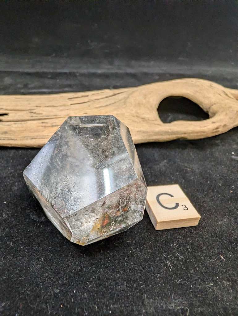 Exact piece Garden Quartz faceted freeform, displaying high clarity quartz contrasting with deep green chlorite deposits.