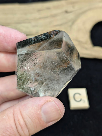 Exact piece Garden Quartz faceted freeform, displaying high clarity quartz contrasting with deep green chlorite deposits.
