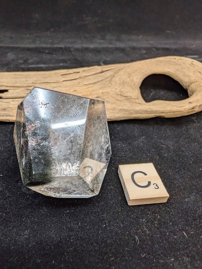 Exact piece Garden Quartz faceted freeform, displaying high clarity quartz contrasting with deep green chlorite deposits.