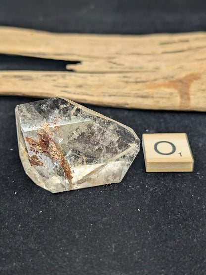 Exact piece Garden Quartz wide freeform, dominated by a striking, dense reddish-brown iron oxide structure cutting diagonally.