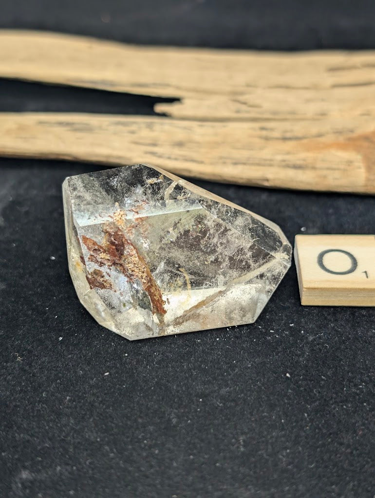 Exact piece Garden Quartz wide freeform, dominated by a striking, dense reddish-brown iron oxide structure cutting diagonally.