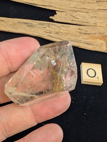Exact piece Garden Quartz wide freeform, dominated by a striking, dense reddish-brown iron oxide structure cutting diagonally.