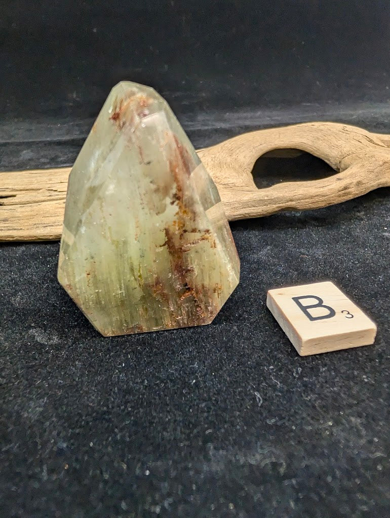 Exact piece Garden Quartz faceted freeform, featuring golden-green chlorite mixed with reddish-brown iron oxide inclusions.
