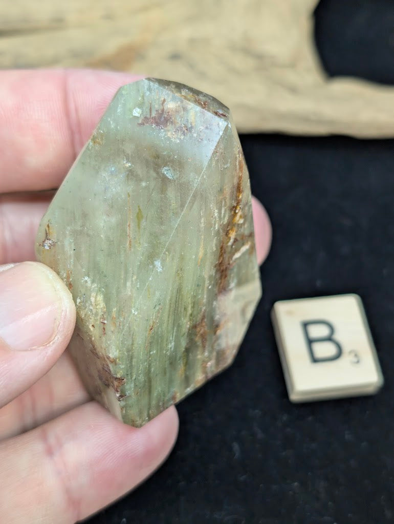 Exact piece Garden Quartz faceted freeform, featuring golden-green chlorite mixed with reddish-brown iron oxide inclusions.