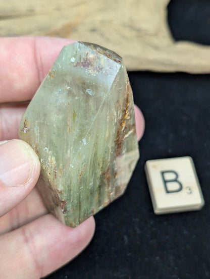 Exact piece Garden Quartz faceted freeform, featuring golden-green chlorite mixed with reddish-brown iron oxide inclusions.