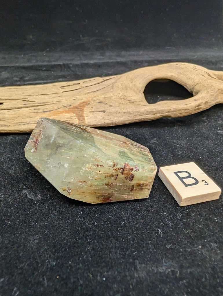 Exact piece Garden Quartz faceted freeform, featuring golden-green chlorite mixed with reddish-brown iron oxide inclusions.