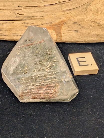 Exact piece Garden Quartz faceted freeform, featuring striking layered horizontal bands of green and red mineral inclusions.