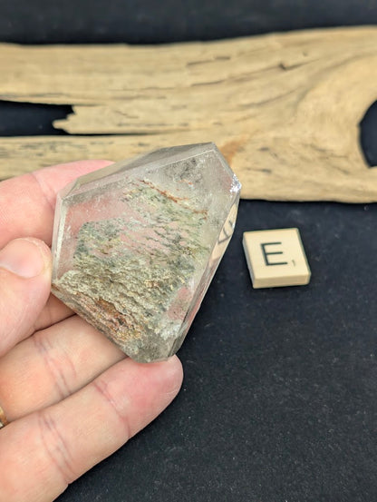 Exact piece Garden Quartz faceted freeform, featuring striking layered horizontal bands of green and red mineral inclusions.