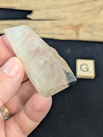 Exact piece Garden Quartz faceted freeform, highly transparent with delicate, sparse pinkish-red and green suspended wisps.