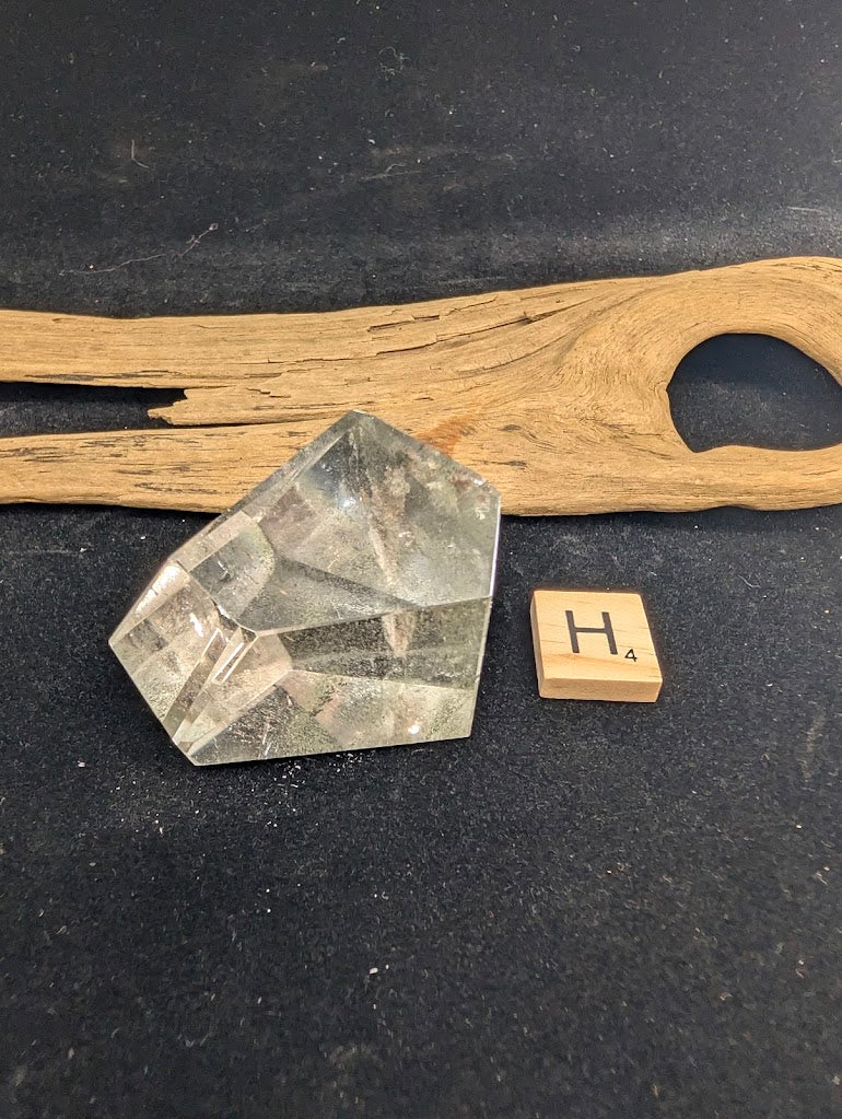 Exact piece Garden Quartz faceted freeform, highly transparent with delicate, sparse pinkish-red and green suspended wisps.