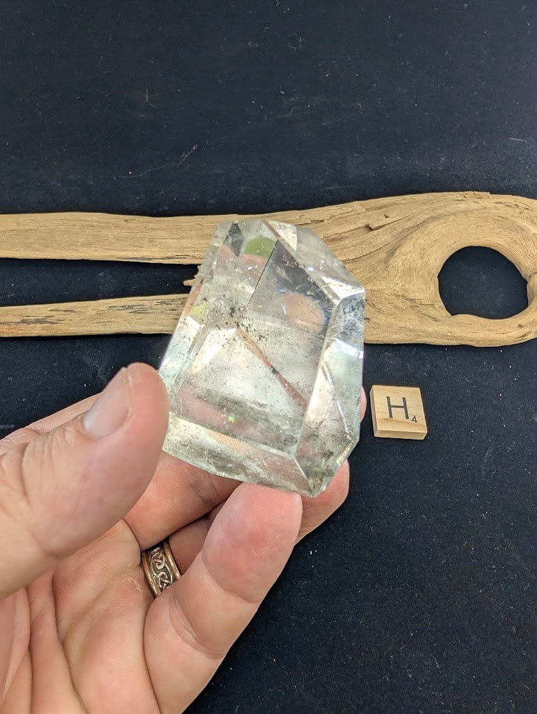 Exact piece Garden Quartz faceted freeform, highly transparent with delicate, sparse pinkish-red and green suspended wisps.