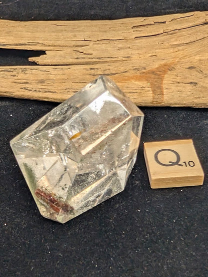 Exact piece Garden Quartz steep point freeform, featuring high clarity and a distinct deep red tubular inclusion near the base.