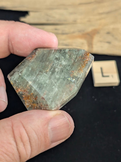 Exact piece Garden Quartz broad wedge, displaying dense, sweeping horizontal green chlorite bands framed by rusty red edges.