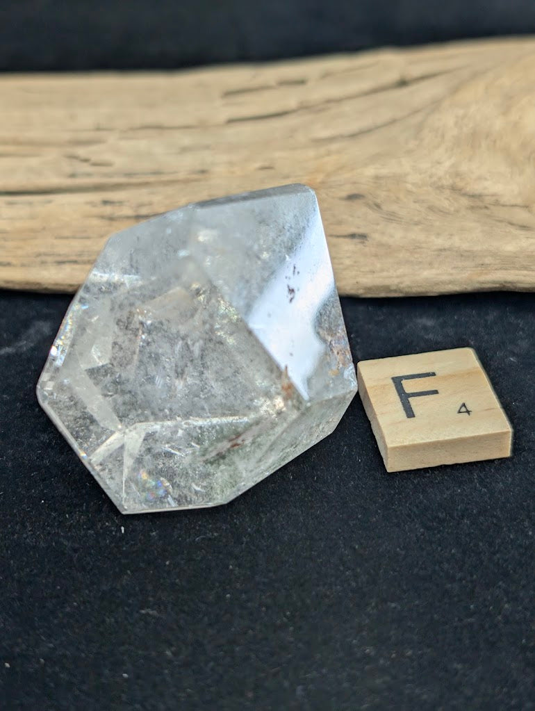 Exact piece Garden Quartz faceted tapered wedge, featuring a single highly concentrated dark green chlorite inclusion at the base.