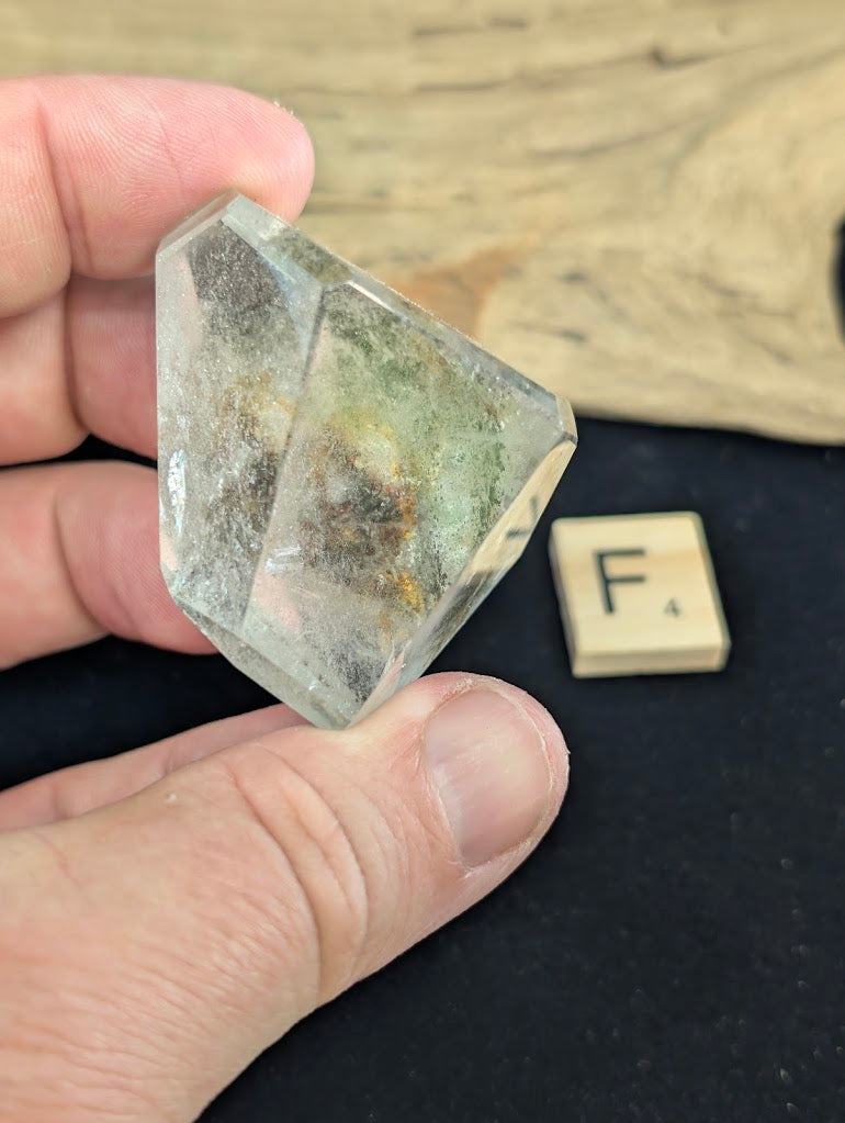 Exact piece Garden Quartz faceted tapered wedge, featuring a single highly concentrated dark green chlorite inclusion at the base.