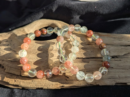 An 8mm Garden Quartz round bead stretch bracelet featuring natural rutile and chlorite inclusions, positioned on a neutral presentation surface.