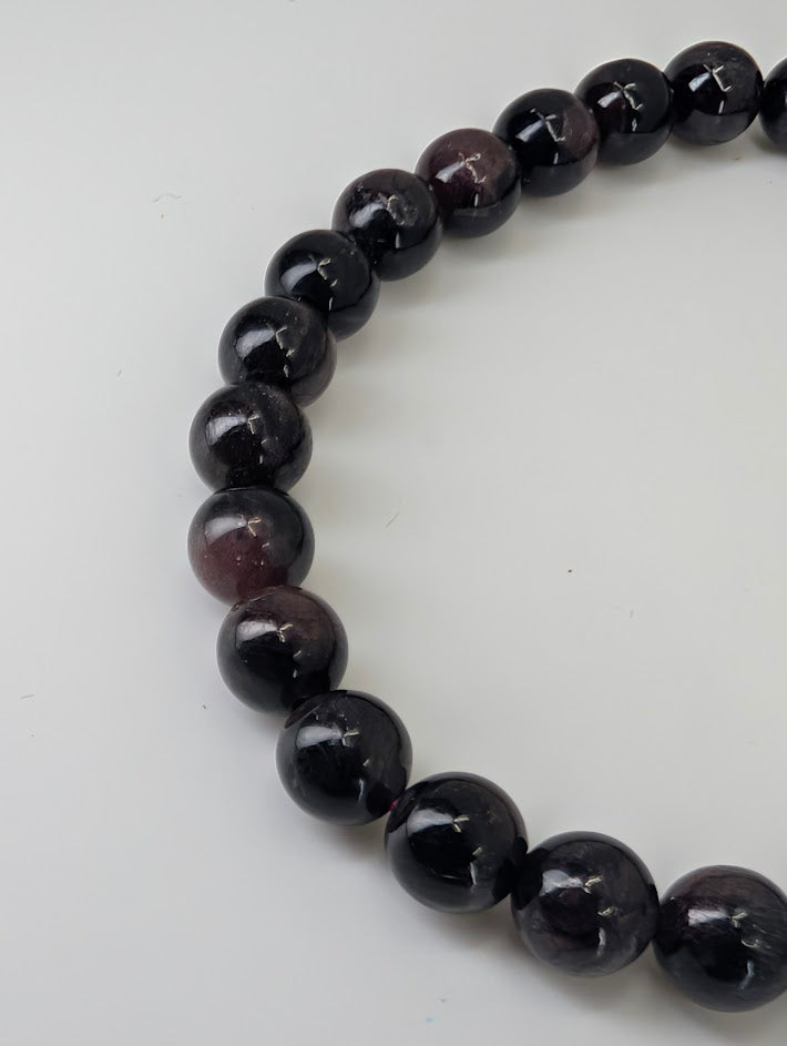 Closeup of 6mm garnet with Astrophyllite bracelet