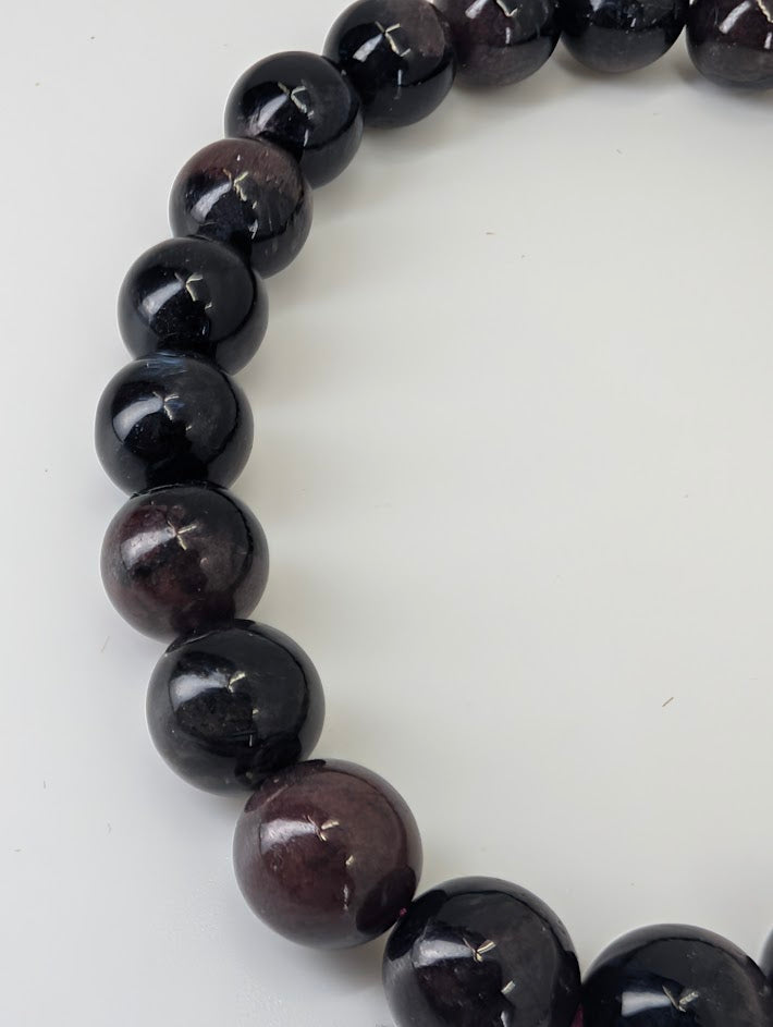 Closeup of 8mm garnet with Astrophyllite bracelet