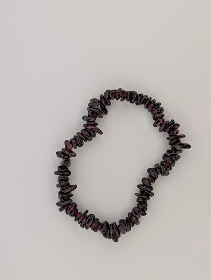 Garnet chip bracelet flat lay with tumbled pieces on stretch cord