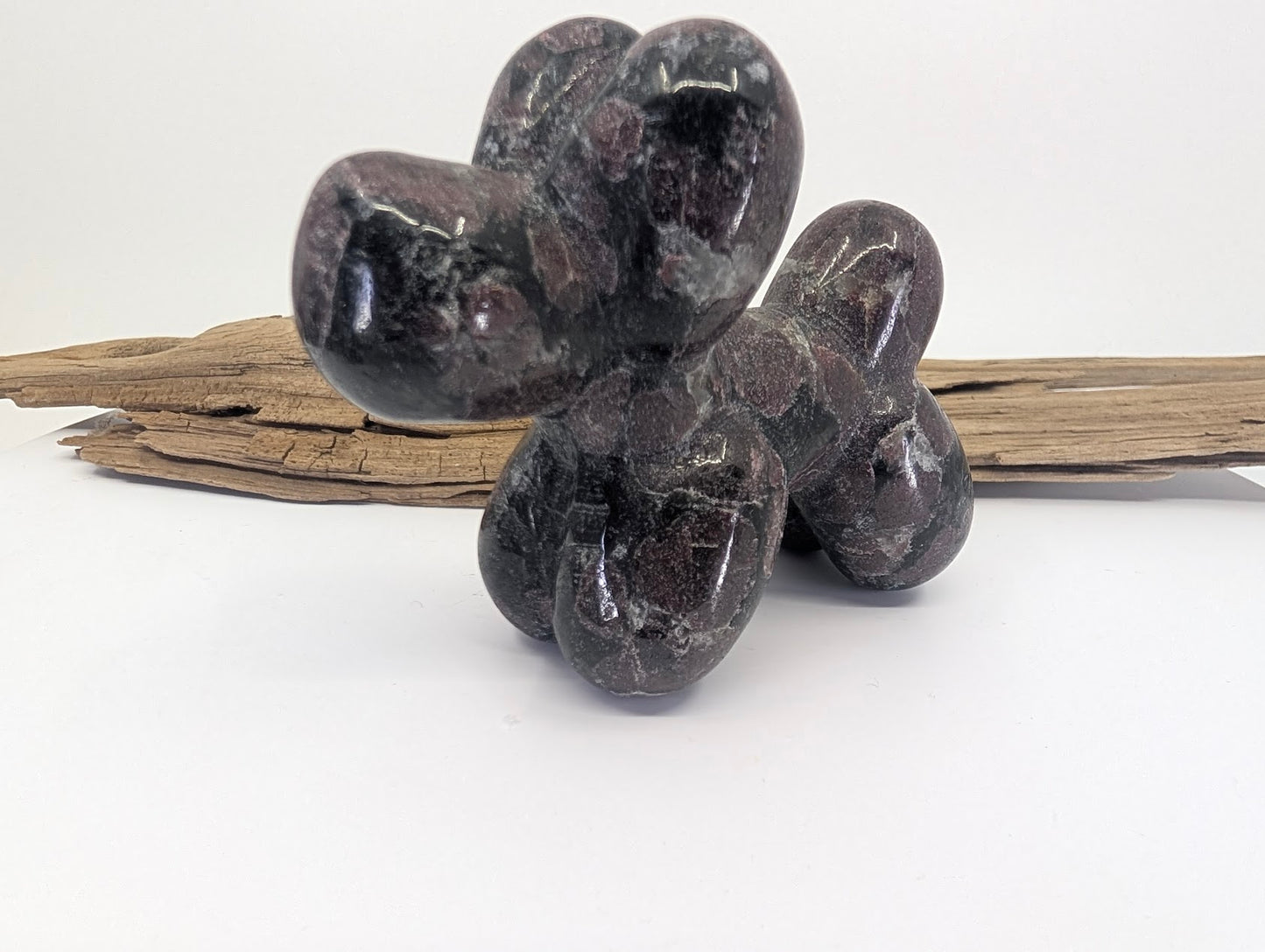 Three-quarter view of Garnet in Matrix balloon dog A showing deep burgundy crystal inclusions.