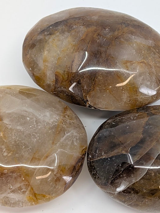 Golden Healer Quartz palm stone showing honey and amber hues with natural internal veils