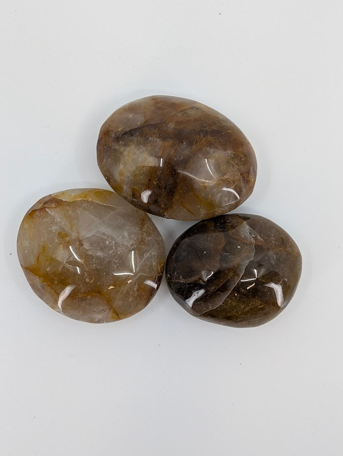 Golden Healer Quartz palm stone close-up highlighting golden ribbons and polished surface