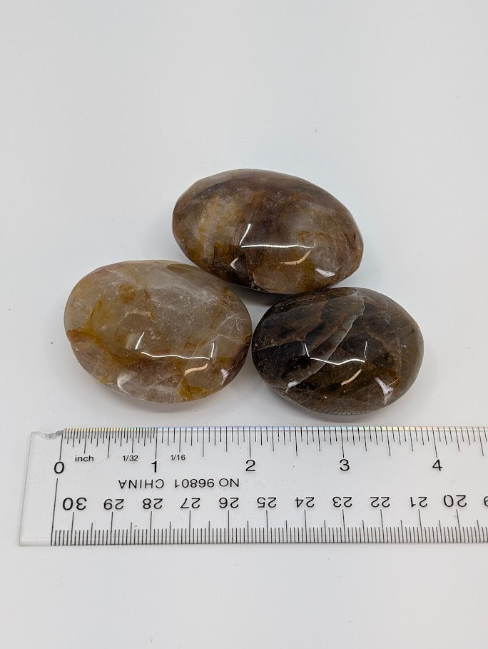 Golden Healer Quartz palm stone angled view showing depth and internal clarity