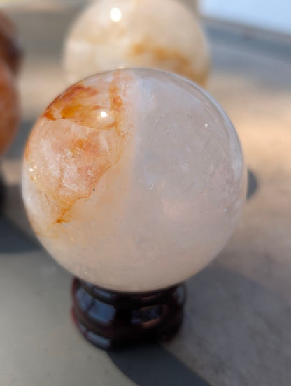 Exact-piece Golden Healer (ferruginous quartz) sphere from Brazil. 69mm variant GHS-01 featuring a sharp boundary between clear quartz and undulating red inclusions.