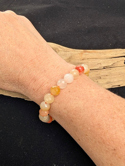 8mm faceted Golden Jade beaded stretch bracelet worn on a wrist for size scale.