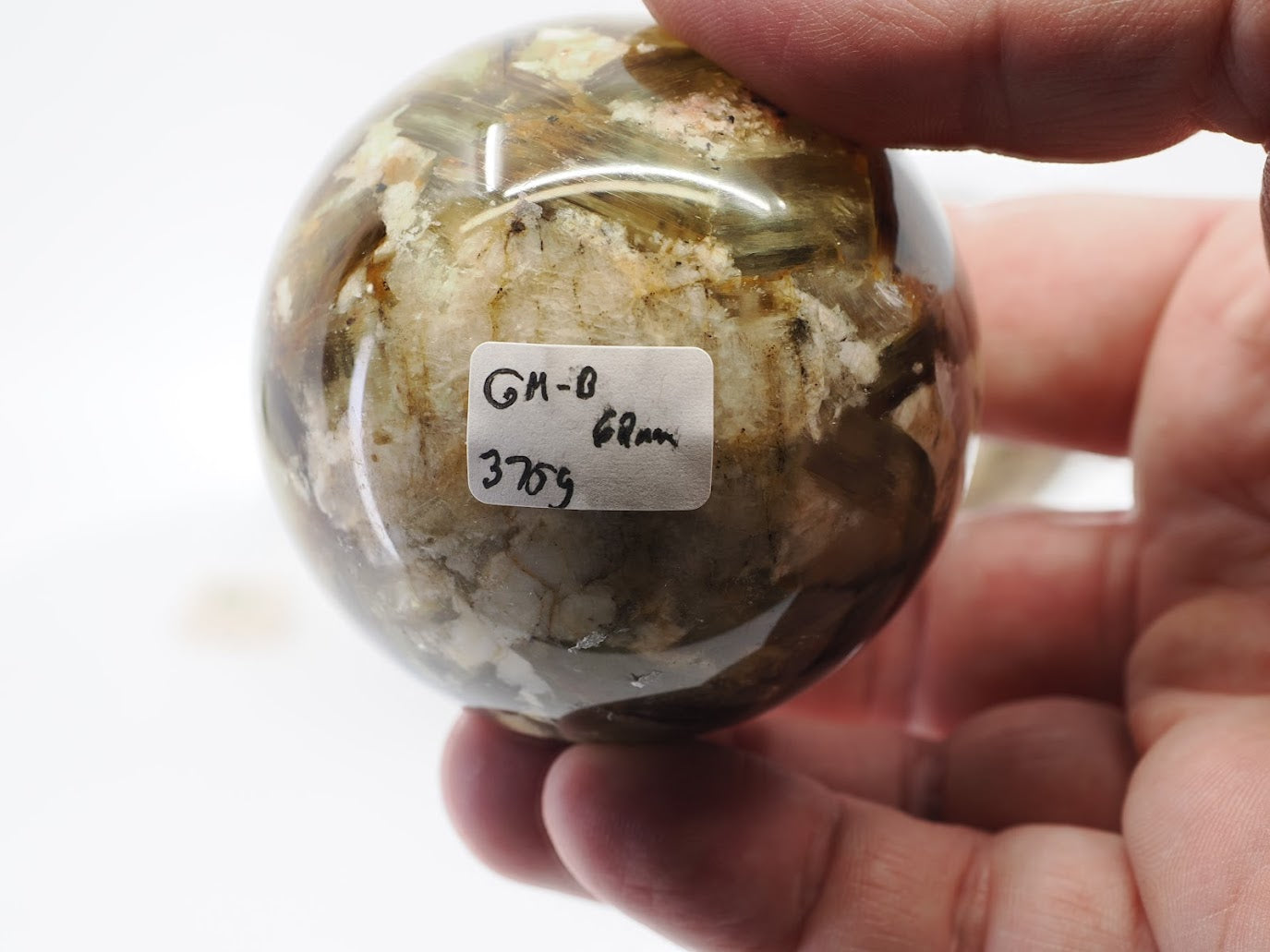 Close-up of Golden Mica sphere B showing 68mm size and 370g weight label highlighting the internal leafy crystal structure.