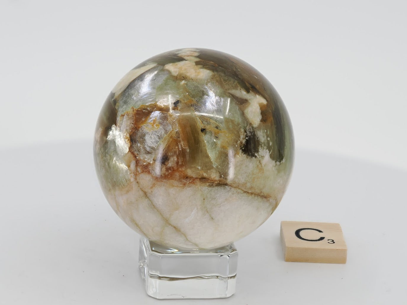 Exact-piece C: 55mm Golden Mica sphere with creamy quartz veins and bright golden chatoyant flashes on a polished surface.