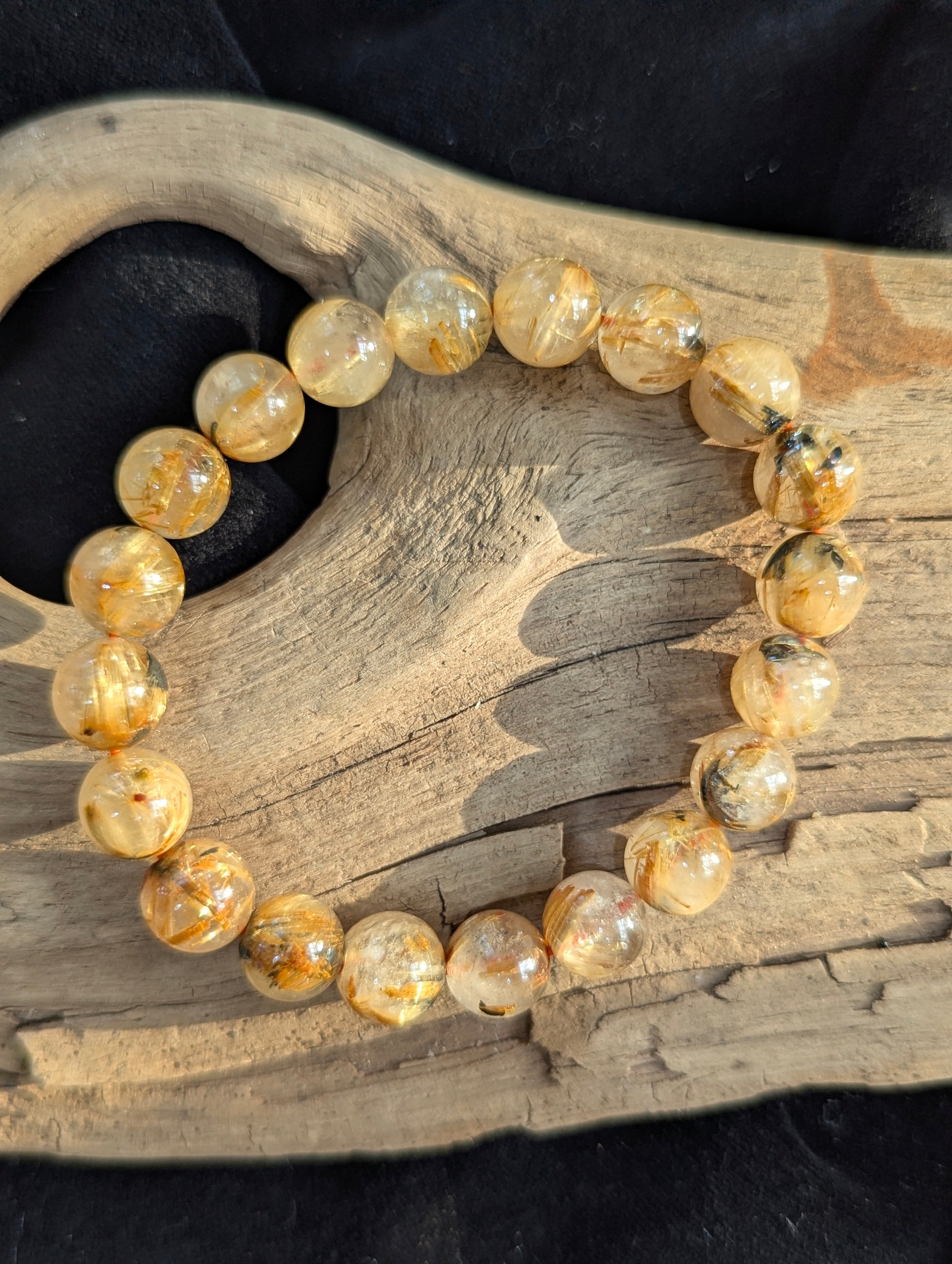 A 10mm Golden Rutilated Quartz bracelet sourced from Brazil, displaying excellent bead clarity and brilliant metallic golden starburst formations.