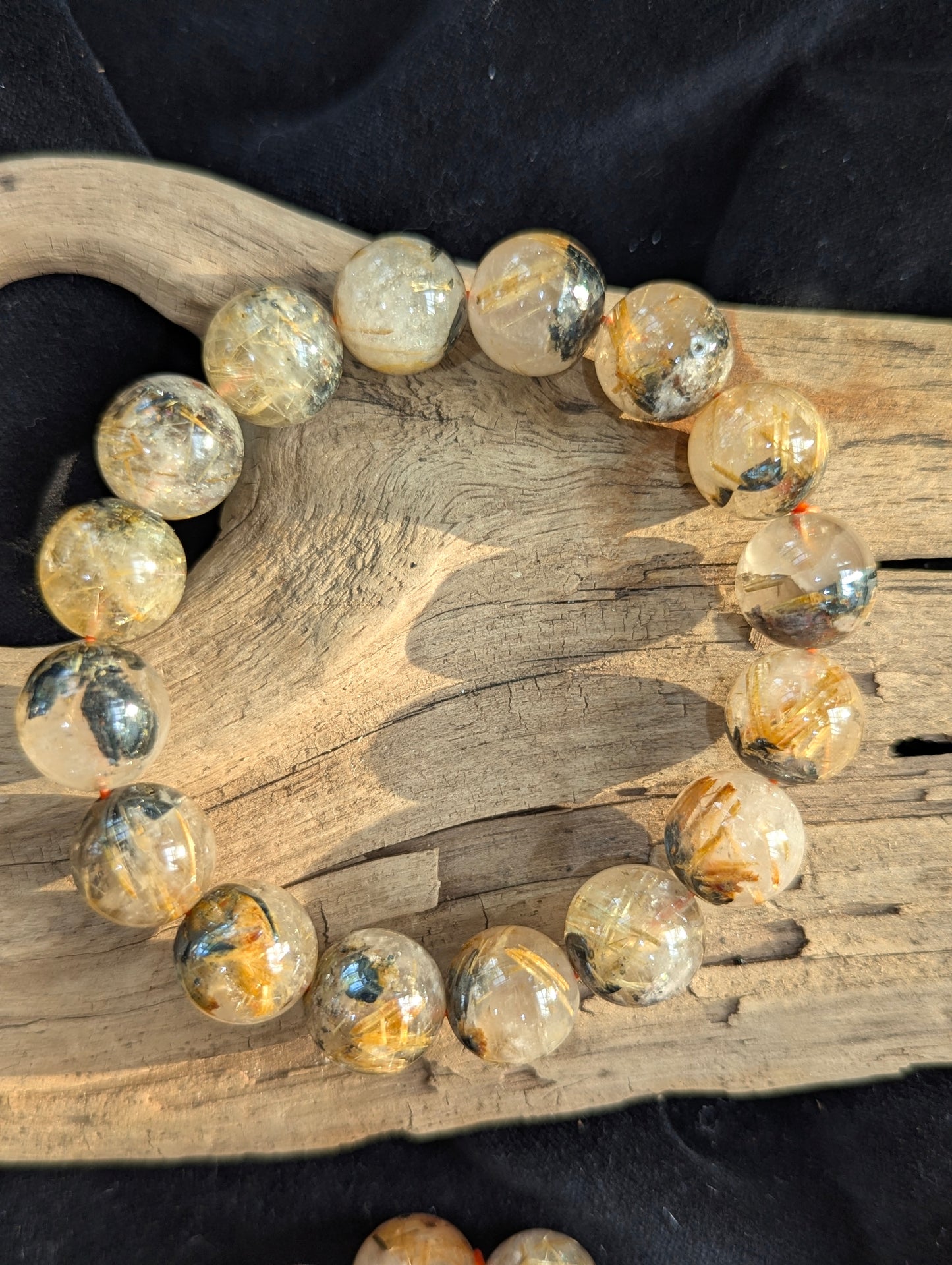 An oversized 13mm statement Golden Rutilated Quartz bracelet. The large bead diameter provides a pristine optical window into the intricate golden rutile crystalline networks.