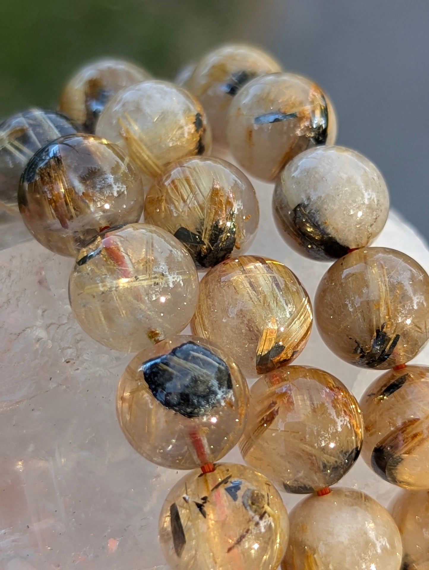 Multiple sizes of AA-grade Golden Rutilated Quartz bracelets stacked together, showcasing the consistent quality, high transparency, and rich golden colouration across the lot.