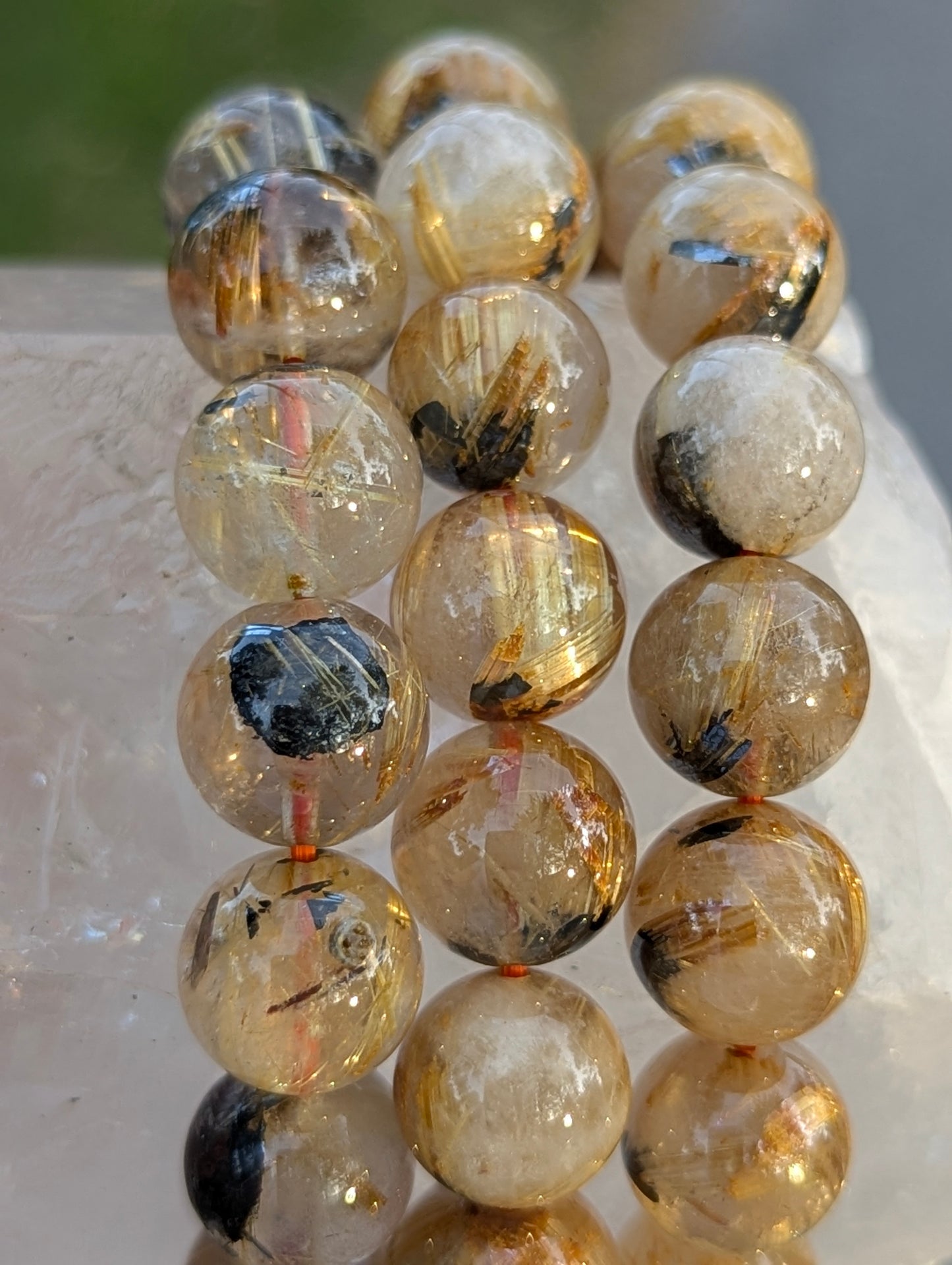 Multiple sizes of AA-grade Golden Rutilated Quartz bracelets stacked together, showcasing the consistent quality, high transparency, and rich golden colouration across the lot.