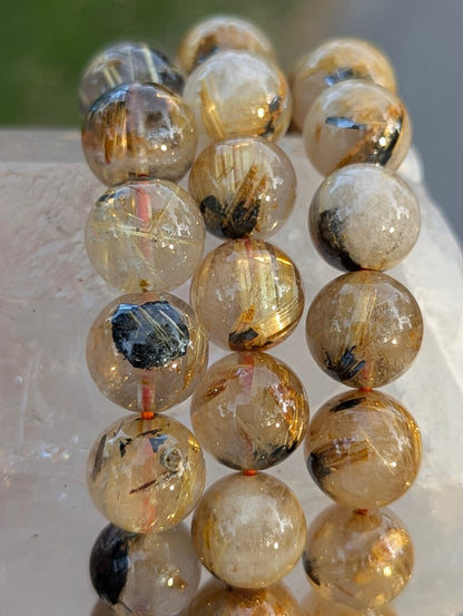 Multiple sizes of AA-grade Golden Rutilated Quartz bracelets stacked together, showcasing the consistent quality, high transparency, and rich golden colouration across the lot.