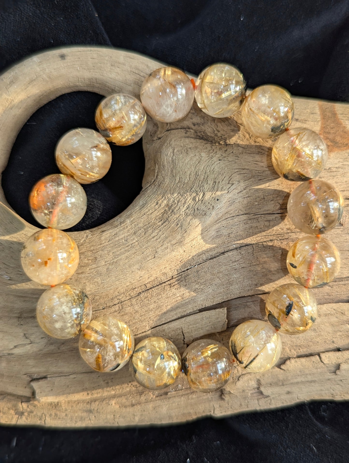 An oversized 13mm statement Golden Rutilated Quartz bracelet. The large bead diameter provides a pristine optical window into the intricate golden rutile crystalline networks.