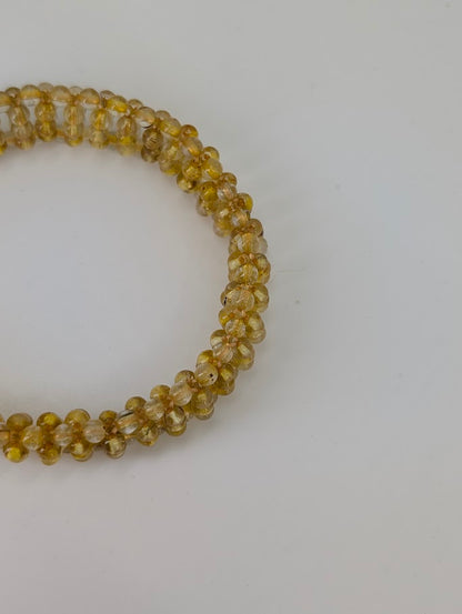 Close-up of golden rutile inclusions inside translucent quartz beads