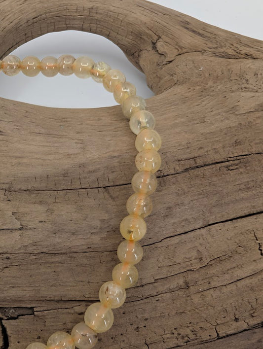 Close-up of Golden Rutile Quartz beads showing internal rutile threads