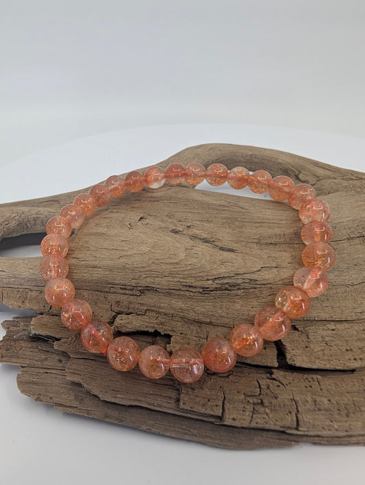 6mm Golden Sunstone bracelet displayed on driftwood