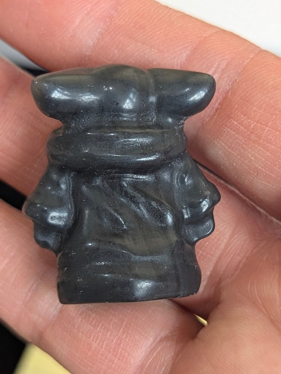 Rear view of a matte Black Obsidian Gorku carving showing the swaddled robe details.