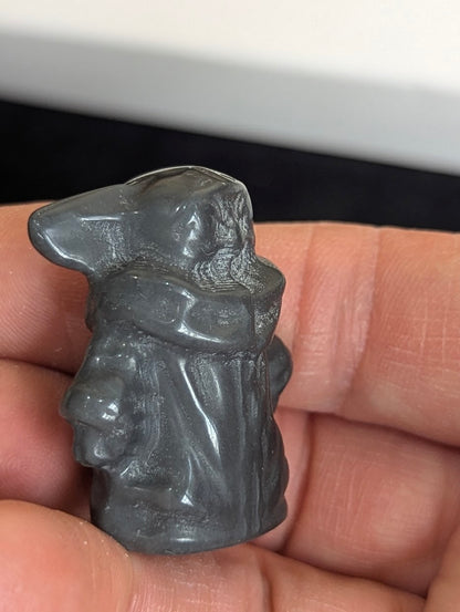 Side profile view of a hand-held matte Black Obsidian Gorku carving.