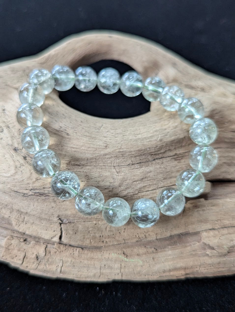 10mm Green Amethyst (Prasiolite) Bracelet, showing pale mint colour and delicate internal inclusions on driftwood.